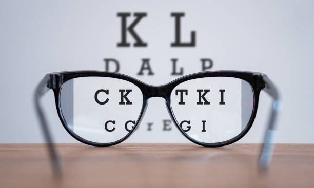 Eyeglasses during optometric examination concept with wooden table, Glasses on table and alphabet letter front view.