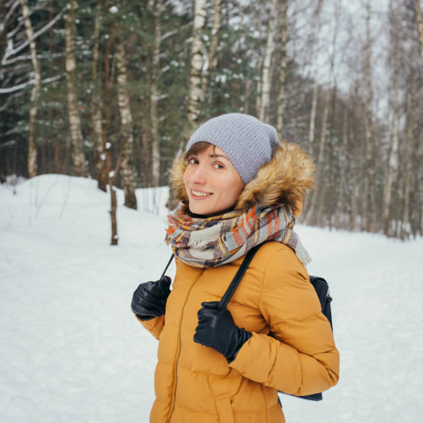 istock Woman walking through winter forest 1286842433