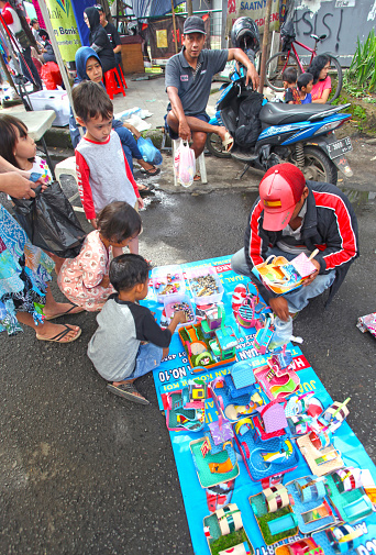 Bandung, West Java, Indonesia - December 11, 2016. Car Free Day is held every Sunday morning at the upper end of Jalan Buah Batu in the city of Bandung. A man selling small foam houses with small hermit crabs.