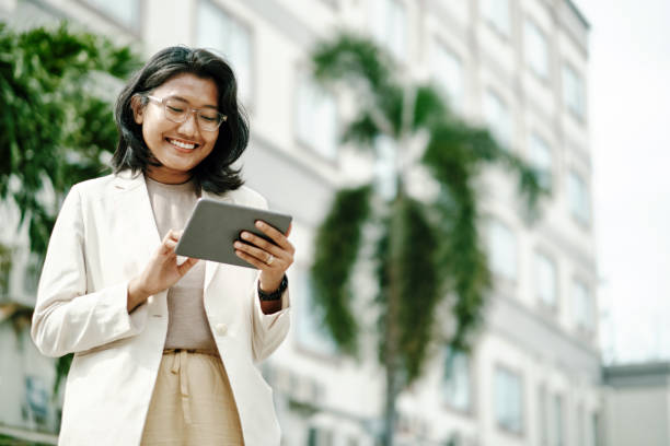 Young Asian Woman Analysing Legal Data on Tablet Single person analyzing legal data on a screen indonesian ethnicity stock pictures, royalty-free photos & images