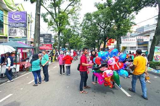 Bandung, West Java, Indonesia - December 11, 2016. Car Free Day is held every Sunday morning at the upper end of Jalan Buah Batu in the city of Bandung. Some people are selling various goods and some are walking around.