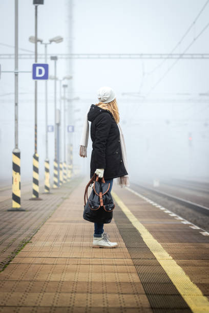 reisende wartet im nebel auf zug am bahnsteig - leaving loneliness women railroad track stock-fotos und bilder