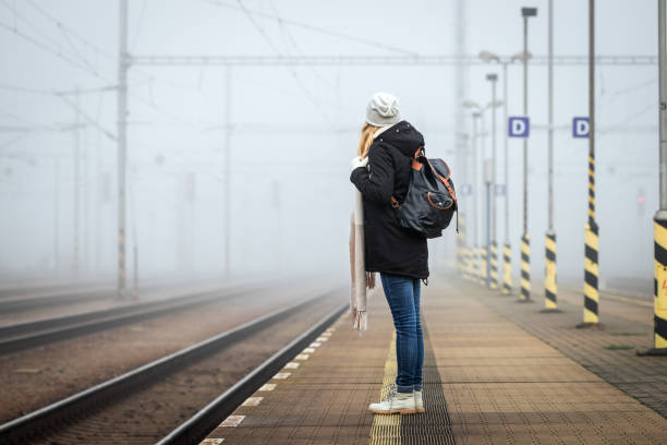 frau wartet auf zug am bahnsteig - leaving loneliness women railroad track stock-fotos und bilder