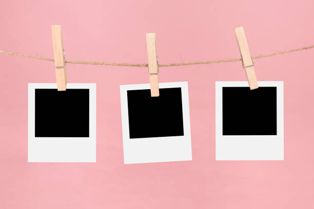 istock Clothesline with three empty picture frames and clothespins on a pink background 1286843661