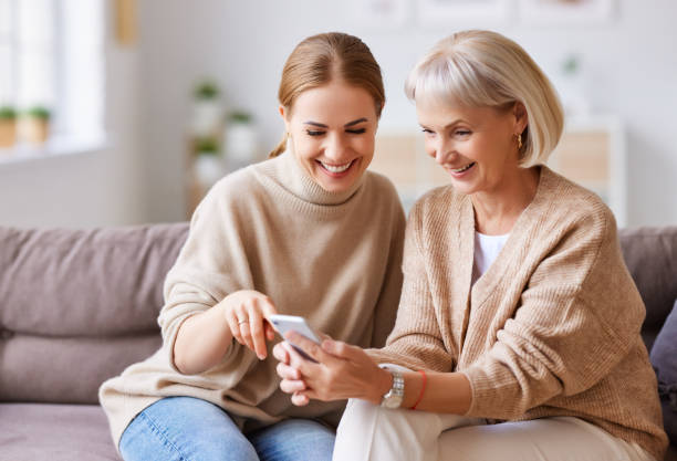 istock Happy mother and daughter using smartphone together 1286845123