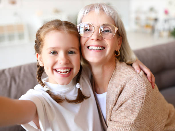 nonna che si fa selfie con il nipote - wireless technology cheerful granddaughter grandmother foto e immagini stock