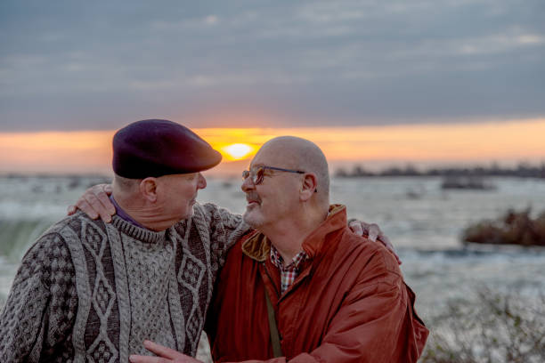 pareja casada gay mayor que visita las cataratas del niágara. - gay man homosexual men kissing fotografías e imágenes de stock