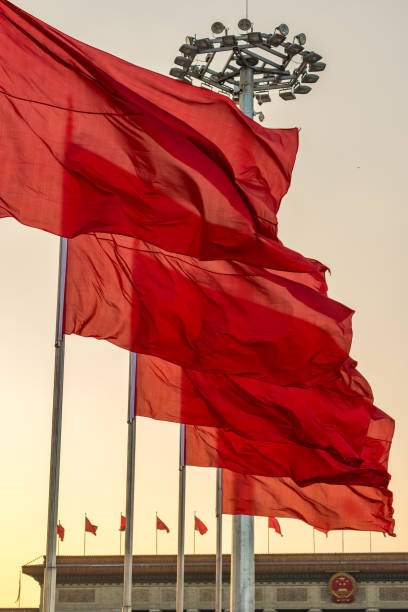 Red banners unfurled in the wind at Tienanmen square in Beijing, China Beijing / China - November 26 2015: Red banners unfurled in the wind at Tienanmen square in front of the Great Hall of the People in Beijing, China xi jinping stock pictures, royalty-free photos & images