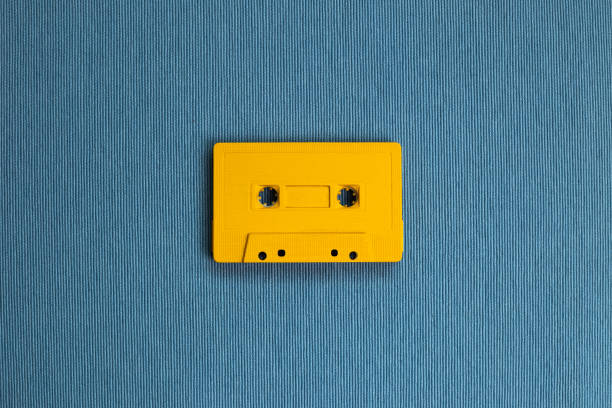 istock Yellow audio cassette tape on blue fabric background. top view, copy space 1286848088