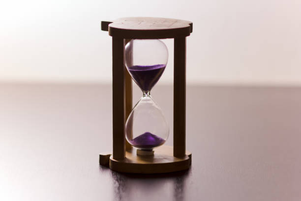 istock Hourglass on shining wooden table 1286848881