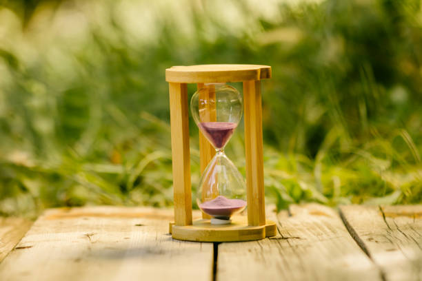 istock Hourglass in the garden with green background 1286848910