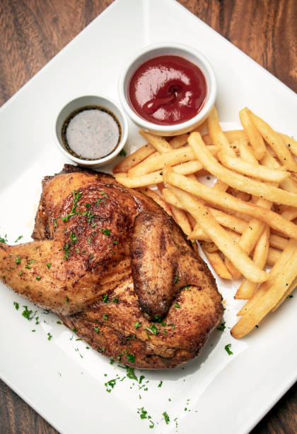 rosticceria arrosto mezzo pollo con patatine fritte pasto semplice su tavolo di legno - rotisserie roast chicken chicken roasted foto e immagini stock