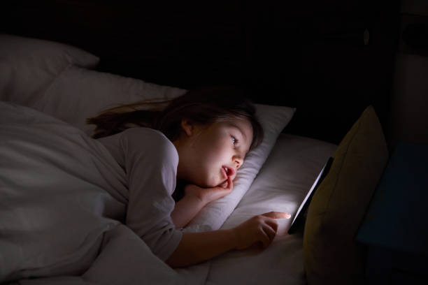 istock little girl on bed touching digital screen 1286850243