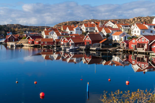 традиционные красные эллинги в порту ховенесет, небольшой рыбацкой деревушке на архипелаге на западном побережье богуслен, швеция - fishing village idyllic red cottage стоковые фото и изображения