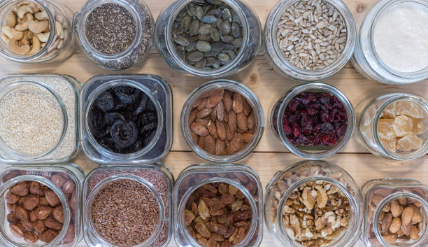 istock Seed,nut and dried fruits in various jars over wood background. 1286854579