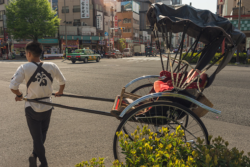 Tokyo / Japan - April 19, 2018: Rickshaw puller waiting for customers in central Tokyo, Japan