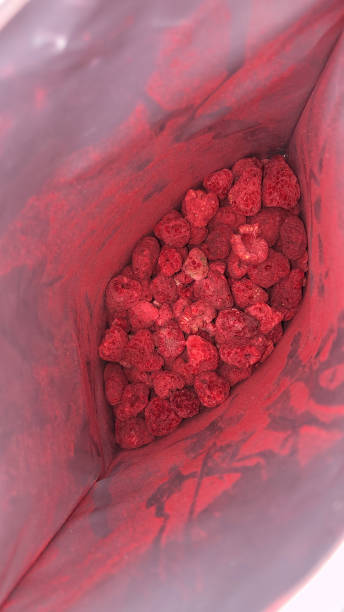 Image of inside foil lined, plastic zip pouch containing freeze dried raspberries, elevated view Stock photo showing elevated view looking at freeze dried raspberries at the bottom of a foil lined ziplock pouch. bottom the weaver stock pictures, royalty-free photos & images