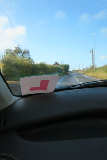 istock Image of passenger view through car windscreen with L Plate, driving on countryside road lined by hedges 1286859401