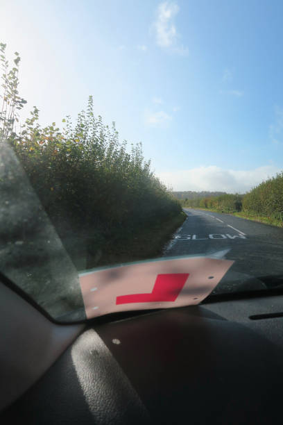 istock Image of passenger view through car windscreen with L Plate, driving on countryside road lined by hedges 1286859402