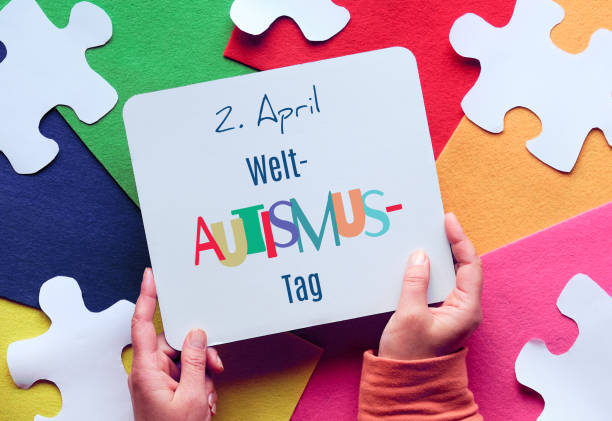 istock Hands hold board. Text in German means April 2 Autism World Awareness day. Puzzle, layered felt 1286860529