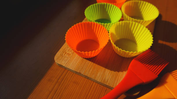 istock Silicone brush and cupcake liners on wooden table 1286860867