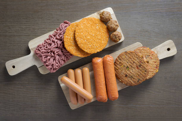 Flat lay of plant based vegetarian meat products. burgers sausage Flat lay of plant based vegetarian meat products for a plant based diet on a wooden table veganism stock pictures, royalty-free photos & images