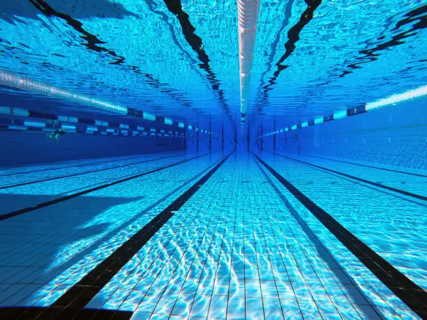 Photo of 50 meter sports pool. Swimming pool underwater background.