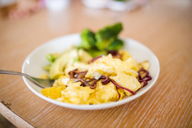 brokkoli und rührei mit avocadoscheiben auf holztisch - fork plate isolated scrambled eggs stock-fotos und bilder