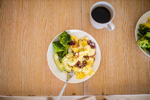 brokkoli und rührei mit avocadoscheiben auf holztisch - fork plate isolated scrambled eggs stock-fotos und bilder