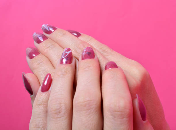 istock female hands with painted nails on pink background. 1286867123