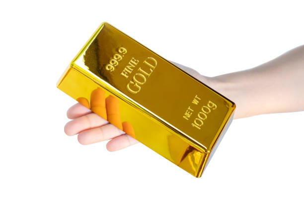istock Human hand holding gold bar 1kg on white background with clipping path 1286867486