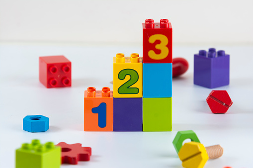 A series of toy building blocks, numbered in ascending order, are surrounded by other colorful toys.