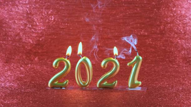 istock Extinct gold New Year's candles 2021 on red background. modern concept 1286868872