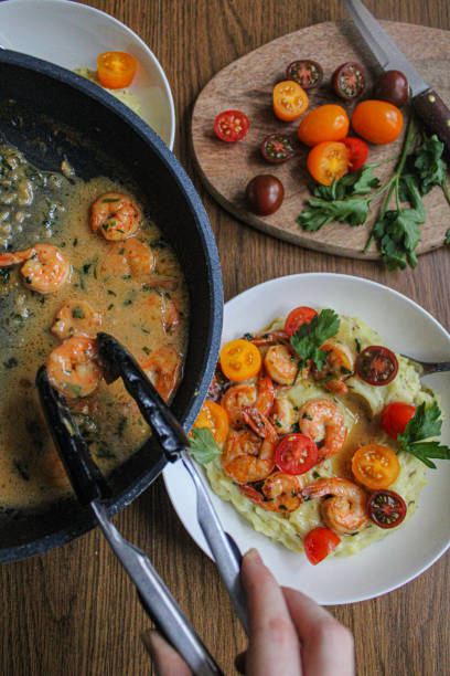 istock Pouring shrimps with garlic sauce over mashed potatoes plate. Plating spring dish. 1286870437