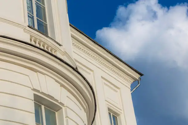 classicism style white house architecture fragment with blue sky and white cloud
