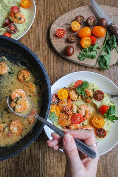 istock Pouring shrimps with garlic sauce over mashed potatoes plate. Plating spring dish. 1286870480