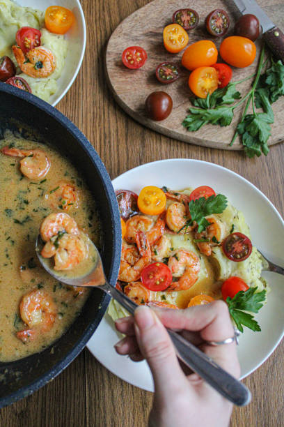 istock Pouring shrimps with garlic sauce over mashed potatoes plate. Plating spring dish. 1286871067