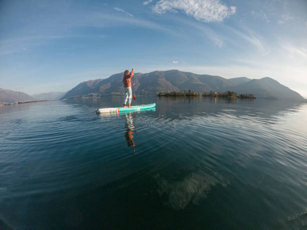 istock Young woman paddling on a paddle board on a lake 1286875915