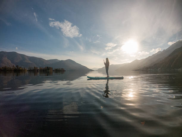 istock Young woman paddling on a paddle board on a lake 1286875995