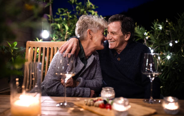 istock Senior couple with wine in the evening on terrace, hugging. 1286876212