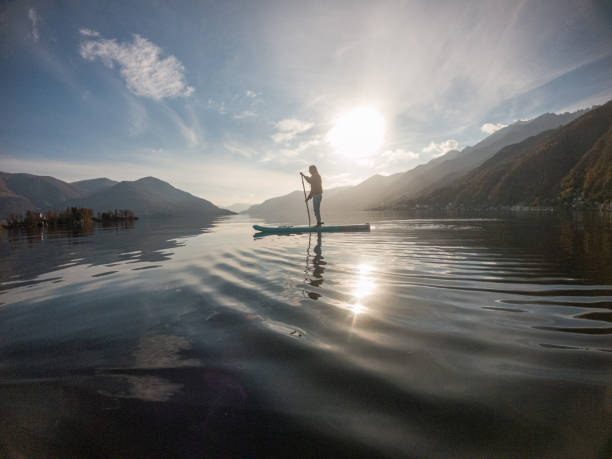 istock Young woman paddling on a paddle board on a lake 1286876971