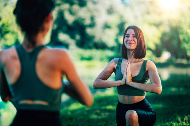 istock Women Doing Yoga by the Lake 1286877056