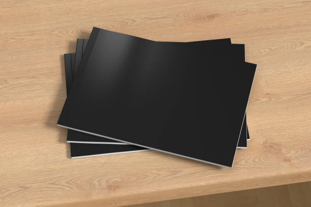 istock Horizontal or landscape black magazine or brochure stack mockup on wooden table. 1286878404