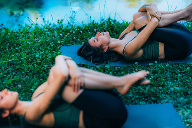 istock Yoga Women by The Water. Wind Relieving Pose. 1286878836