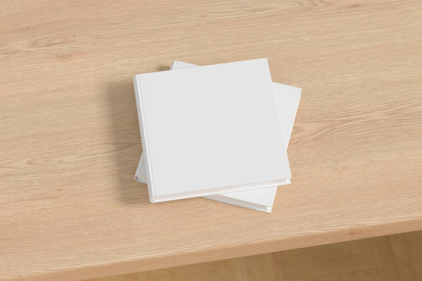 istock Square white hardcover book stack mockup on the wooden table. 1286878875