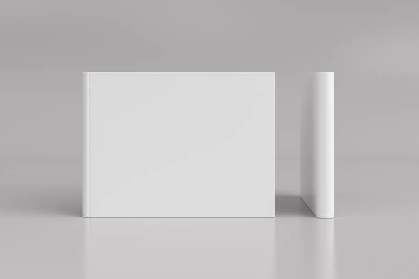 istock Two hardcover horizontal or landscape white mockup books standing on the white background. Blank front cover and spine of book. 1286878925