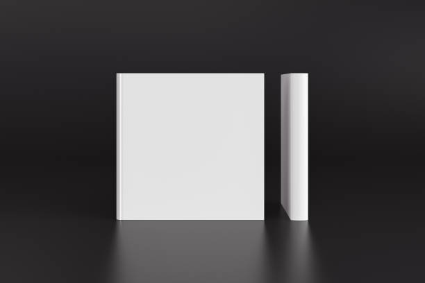 istock Two hardcover  square white mockup books standing on the black background. Blank front cover and spine of book. 1286878936