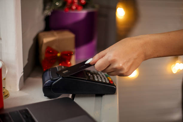 istock Customer is paying with card in christmas shop using NFC technology. NFC technology. Customer is paying 1286879875