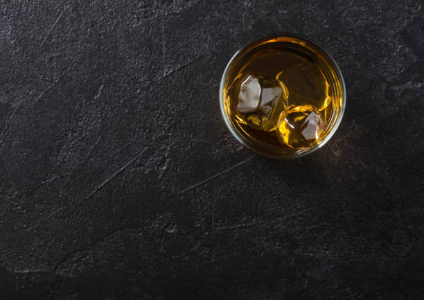 istock Glass with ice cubes of scotch whiskey on black background. 1286881621