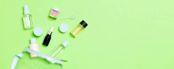 istock Group of small bottles for travelling on green background. Copy space for your ideas. Flat lay composition of cosmetic products. Top view of cream containers with cotton pads 1286883090